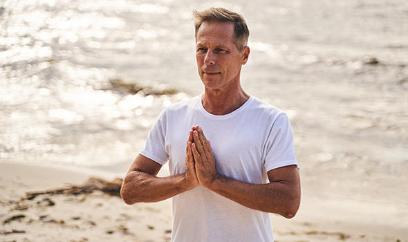 Freepik_calm-male-is-standing-on-sea-shore-and-holding-hands-in-namaste-position-while-practicing-yoga-outdoors_Svitlana Hulko.jpg