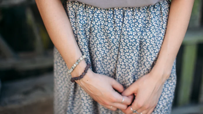 Inkontinenz bei Frauen ist ein Thema, über das viele Betroffene nur ungern sprechen. Frau hält Hände vor den Unterbauch – Symbolbild für Inkontinenz bei Frauen und Blasenschwäche.