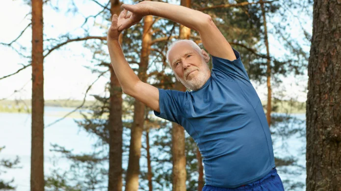 Senior beim Rückentraining im Freien zur Förderung der Beweglichkeit und Stärkung der Wirbelsäule.