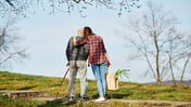Betreuungswelt-Friesch Senior und Betreuungskraft sind gemeinsam draußen unterwegs; die Betreuungskraft trägt eine Einkaufstüte mit Lebensmitteln