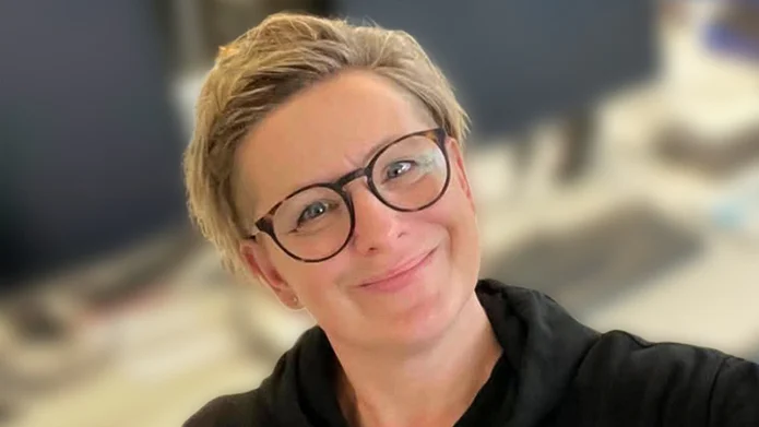 Melanie mit kurzer blonder Frisur und Brille lächelt in die Kamera. Durch ihre Pumpentherapie fühlt sie sich im Alltag wieder flexibler und beweglicher.