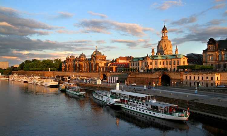 Flusskreuzfahrtschiff liegt vor der Skyline von Dresden vor Anker. 