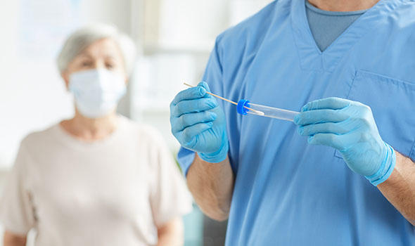 Freepik_unrecognizable-medical-specialist-wearing-blue-uniform-holding-test-tube-and-swab-sample-and-his-patient-sitting-behind-him_seventyfour.jpg