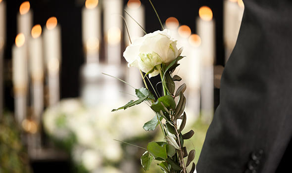 Freepik_woman-holding-white-flower-at-funeral_noxos.jpg