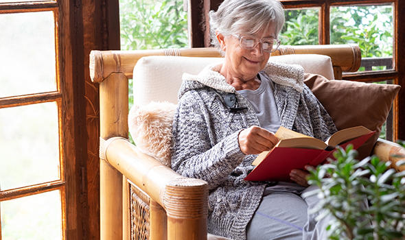 Freepik_old-elderly-woman-sitting-at-home-on-armchair-reading-a-book-wearing-a-warm-sweater-and-eyeglasses-comfortable-living-room-wooden-window_lucigerma.jpg