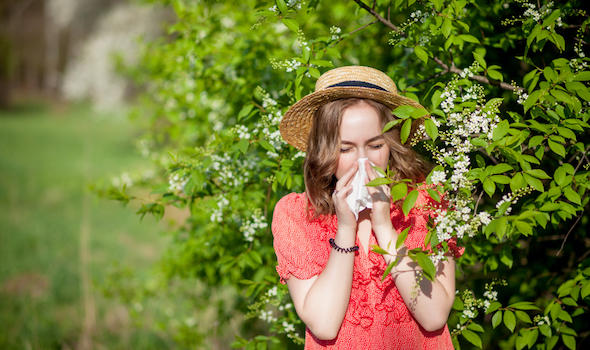 young-girl-blowing-nose-and-sneezing-in-tissue-in-front-of-blooming-tree.jpeg