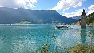 Reschensee_with_Graun_Church_tower_and_boat.jpg